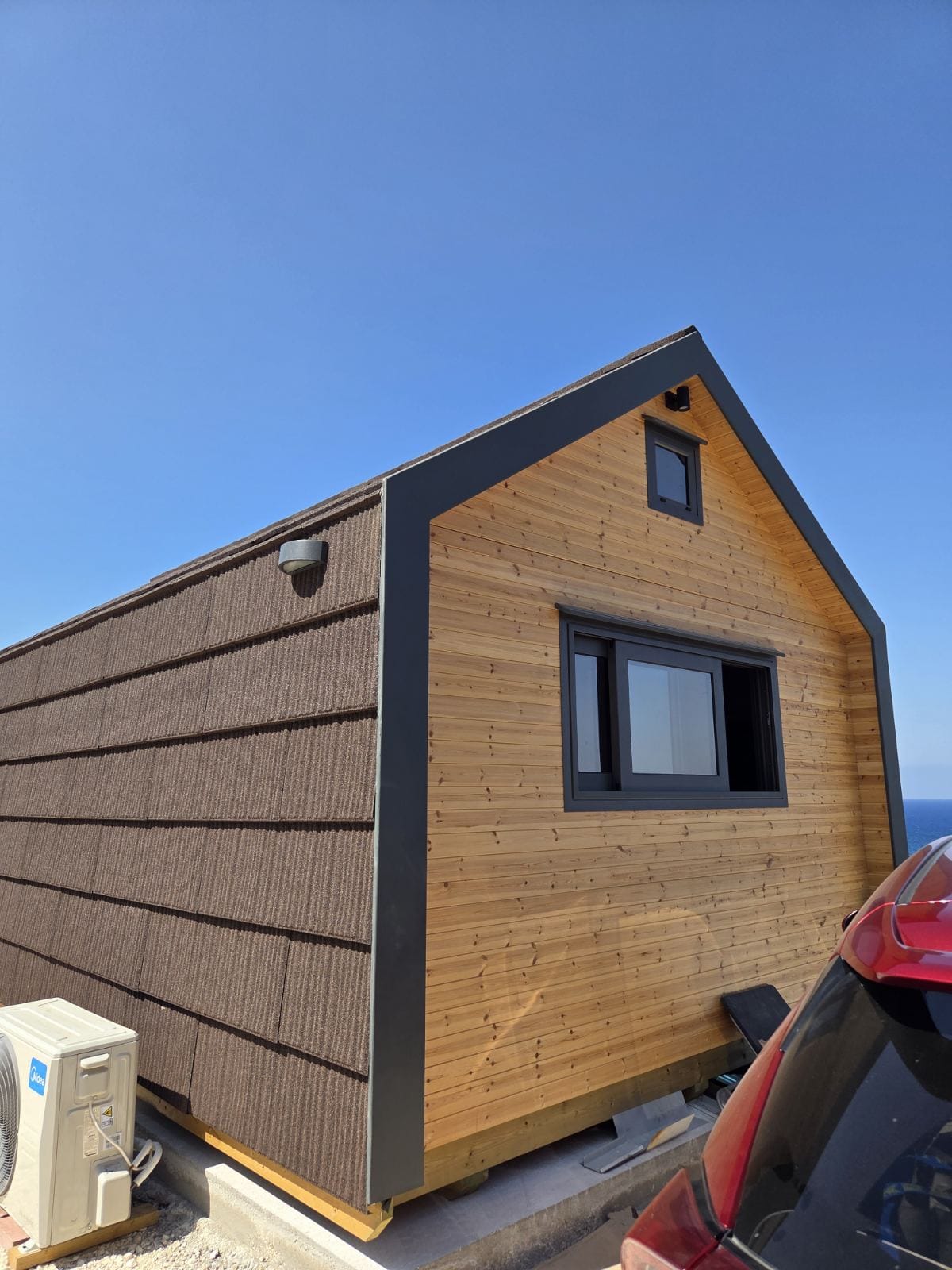 Wooden cabin with a modern design against a clear blue sky. Prefab house Cyprus. Prefabricated modular home Cyprus. Prefabcy. Buy modular home in Cyprus.