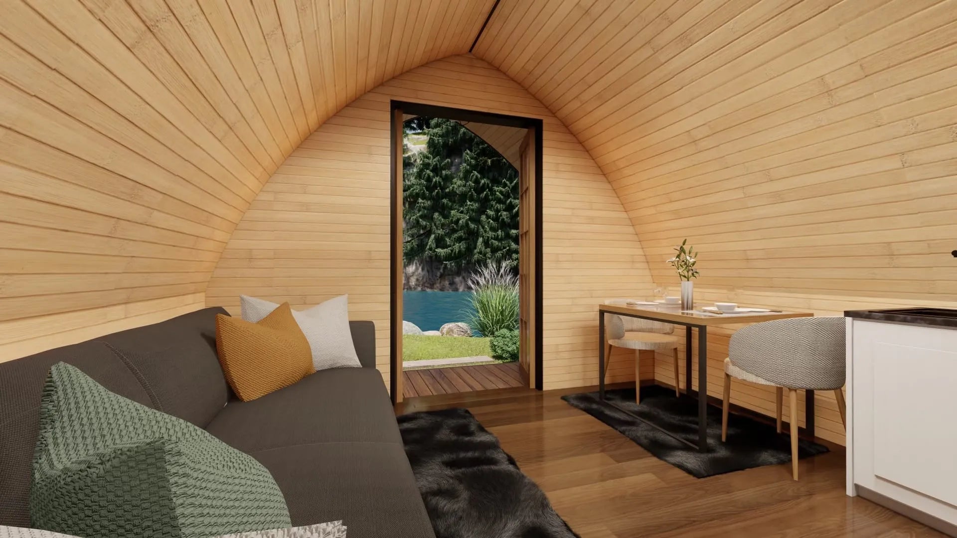 Wooden cabin interior with a sofa, table, and view of greenery outside. Prefab house Cyprus. Prefabricated modular home Cyprus. Prefabcy. Buy modular home in Cyprus.