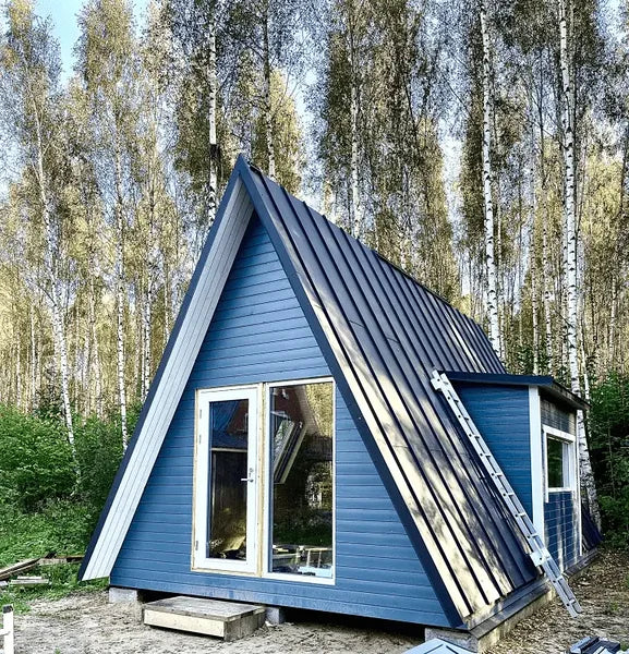 Blue A-frame cabin in a forest setting.  Prefab house Cyprus. Prefabricated modular home Cyprus. Prefabcy