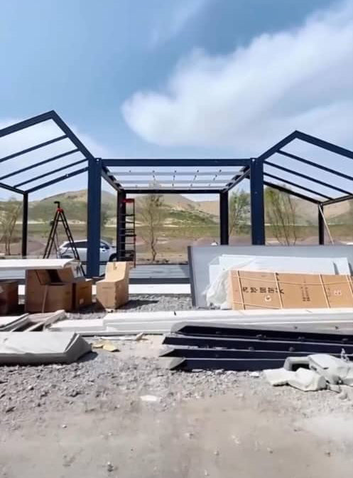 Construction site with metal frame structures and materials on a clear day. Prefab villa, prefab house, prefabricated home, prefab Cyprus, modular villa, modular house, barn house