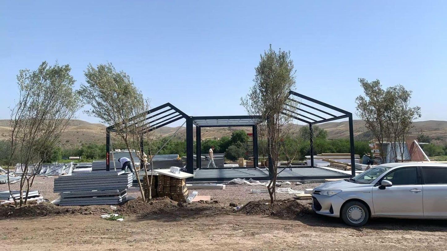 Construction site with a black metal frame structure and a white car parked nearby. Prefab villa, prefab house, prefabricated home, prefab Cyprus, modular villa, modular house, barn house